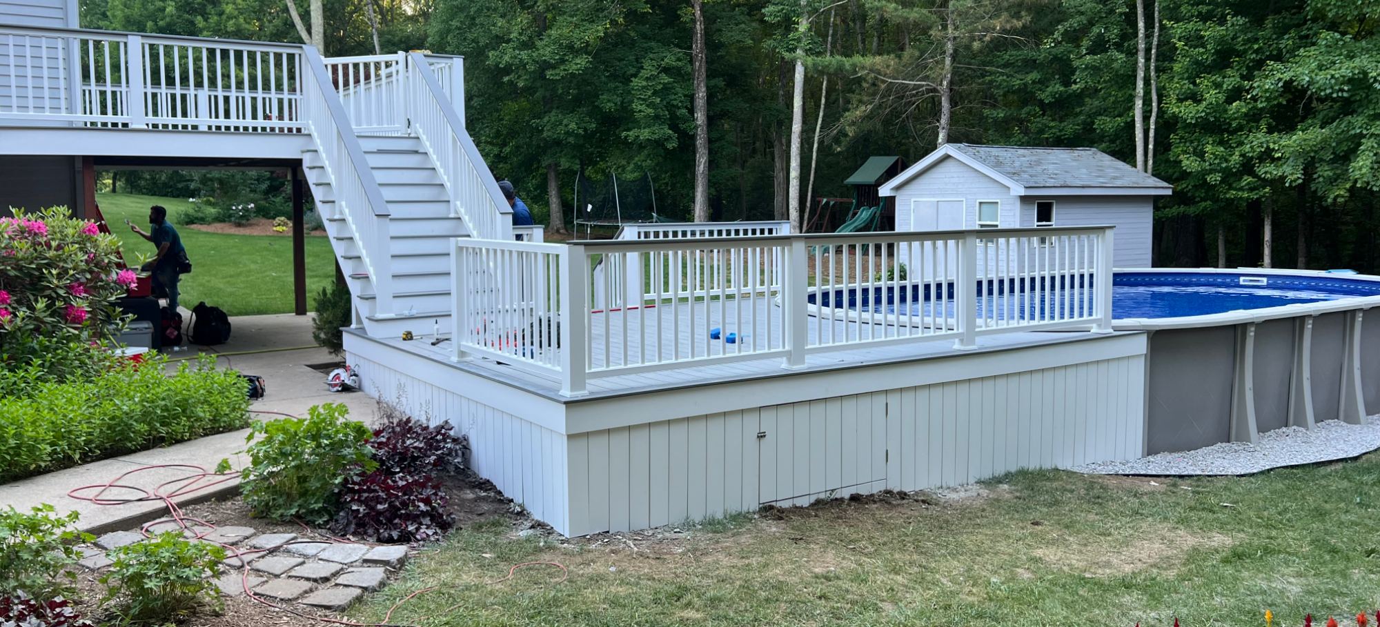 Custom deck with stairs and a wraparound pool deck built by Vanelando Construction